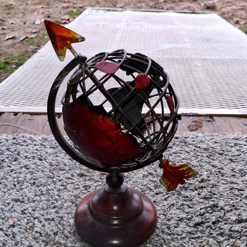 Metal globe with arrow going through it